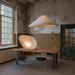 Acoustic tapered pendant lamp paired with round ribbed light fixture in vintage industrial dining room setting with warm lighting