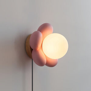 Bloom pink flower wall lamp side close-up wooden base frosted glass shade warm ambient lighting