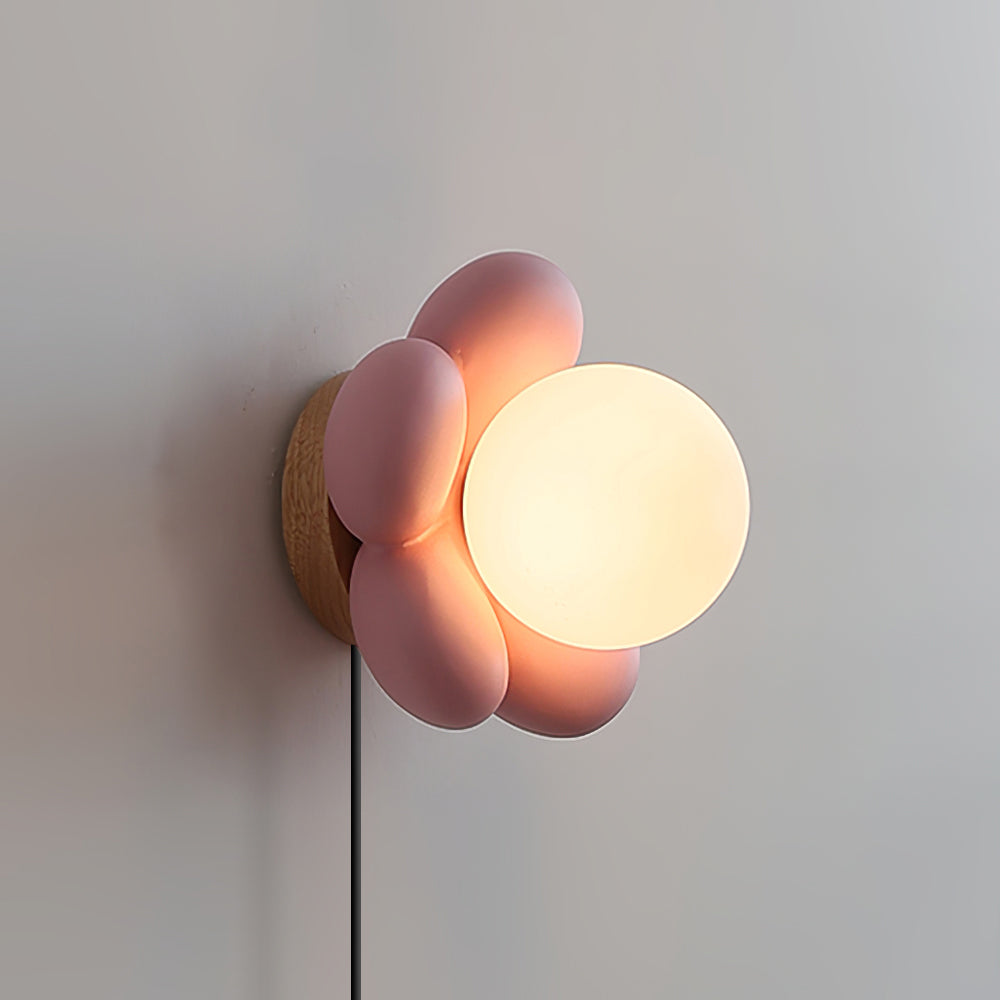 Bloom pink flower wall lamp side close-up wooden base frosted glass shade warm ambient lighting