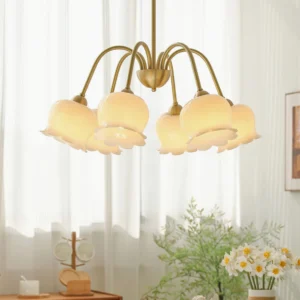 6-arm flower-shaped brass chandelier with bell glass shades installed in sunlit living room with sheer curtains, vintage country styling and warm ambient lighting
