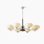 Mid-century modern glass chandelier with 8 cream-colored oval shades, walnut wood central frame, and polished chrome curved arms on white studio background - overhead front view