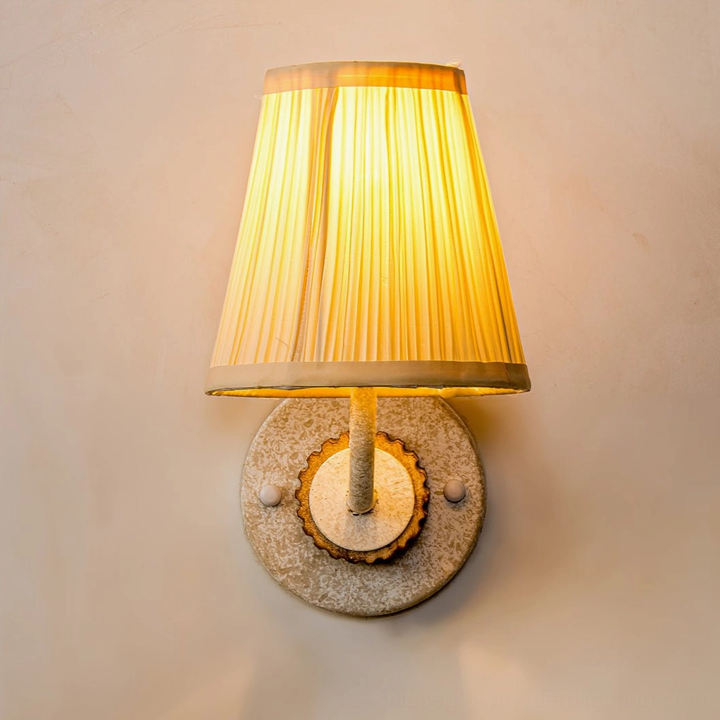 Illuminated Abbey sconce showing warm light diffusion through pleated fabric shade