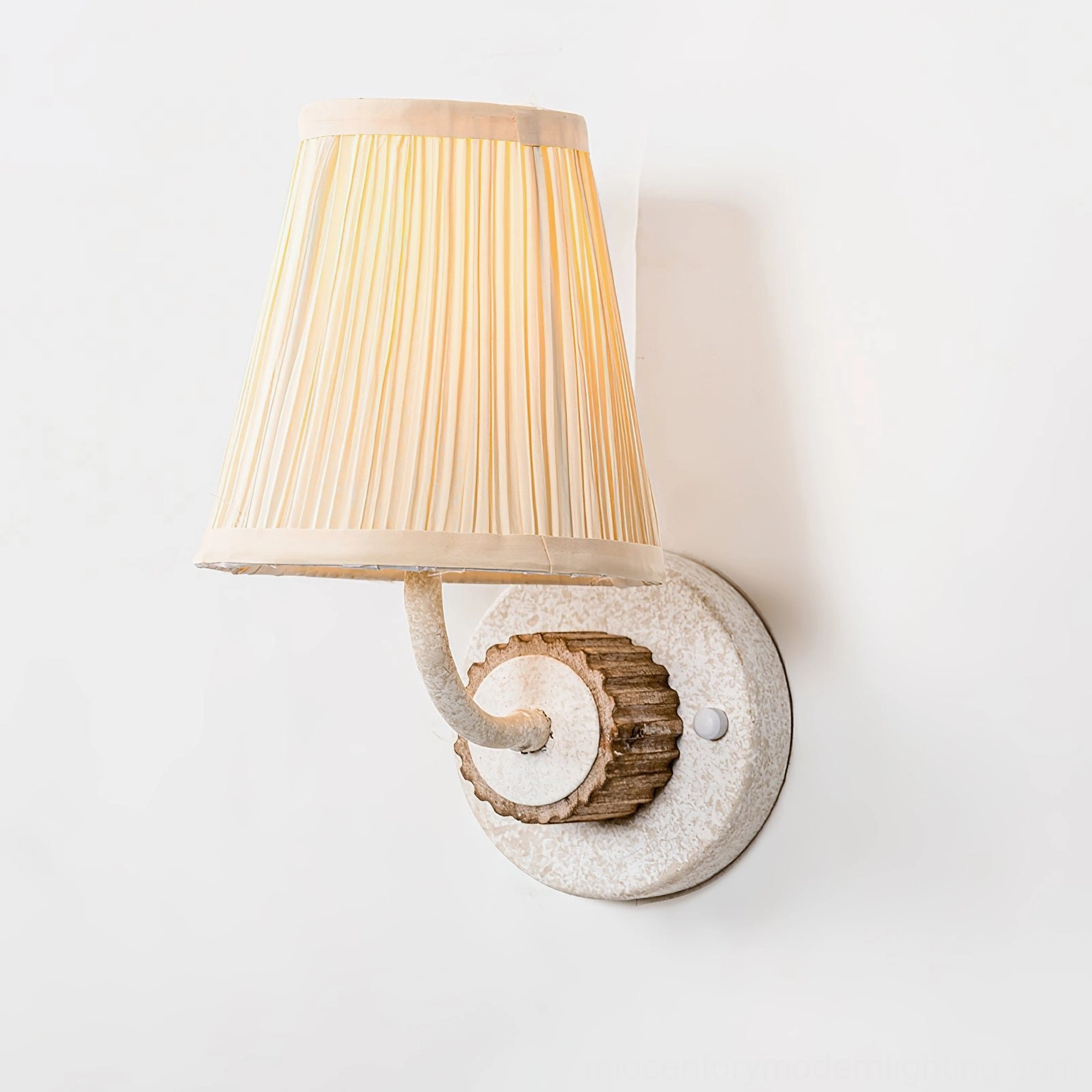 Abbey French Country wall light front overhead view with beige pleated shade and speckled base plate
