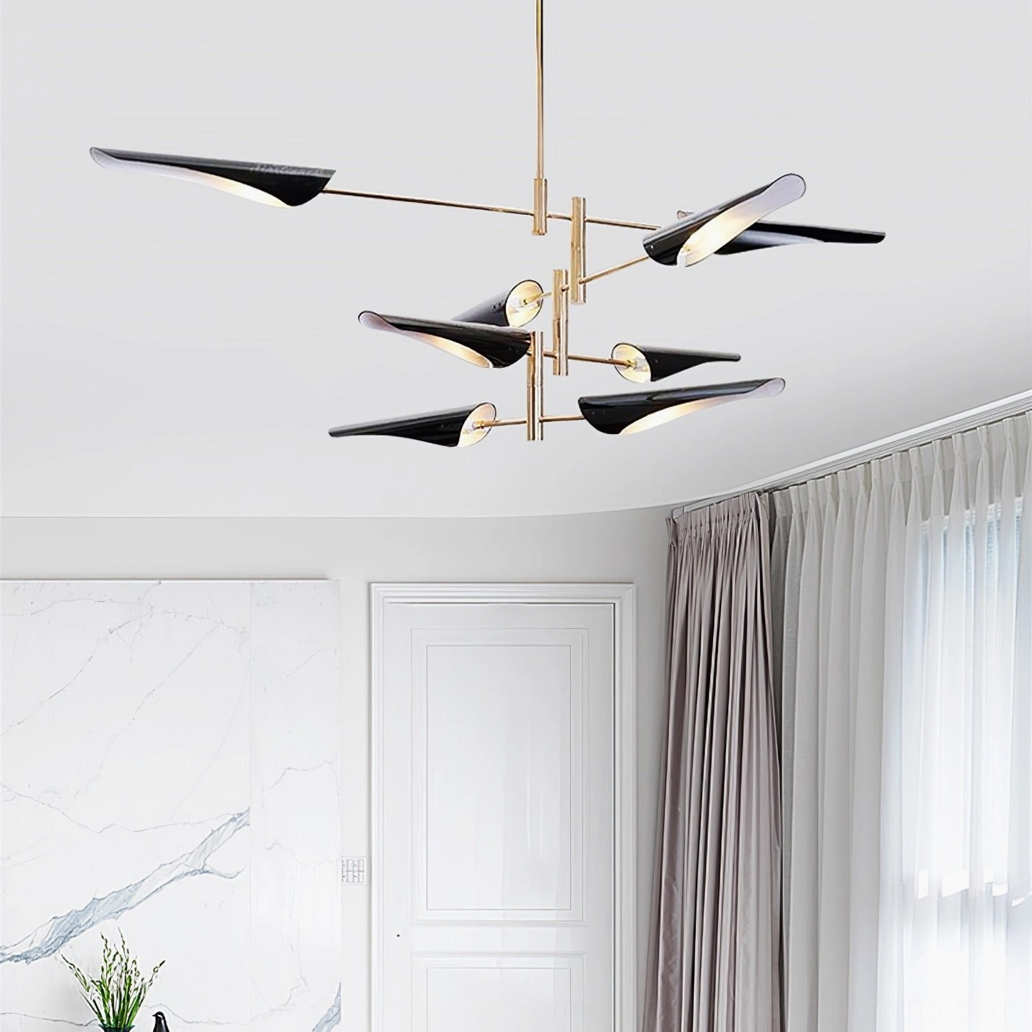 Abelon 2-tier sputnik chandelier installed above marble accent wall in luxury modern living room setting