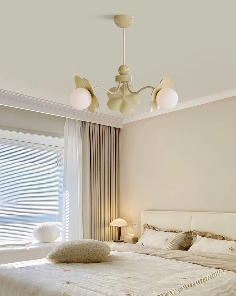 Sage green Acacia 3-light chandelier in cozy cream bedroom with bedside lamp, showing botanical color finish and complementary styling
