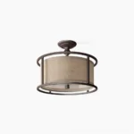 Addyson semi-flush ceiling lamp with antique brass frame and beige fabric drum shade, front view on white background showing transitional modern lighting fixture