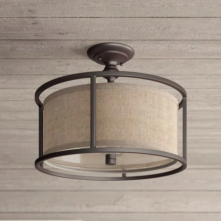 Addyson ceiling lamp side low-angle view displaying round metal ceiling mount base and antique brass frame construction on wood ceiling