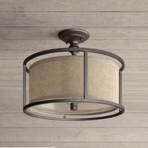Addyson semi-flush ceiling lamp installed on rustic wood plank ceiling, low-angle view showcasing clear lower glass panel and warm diffused light in farmhouse style interior