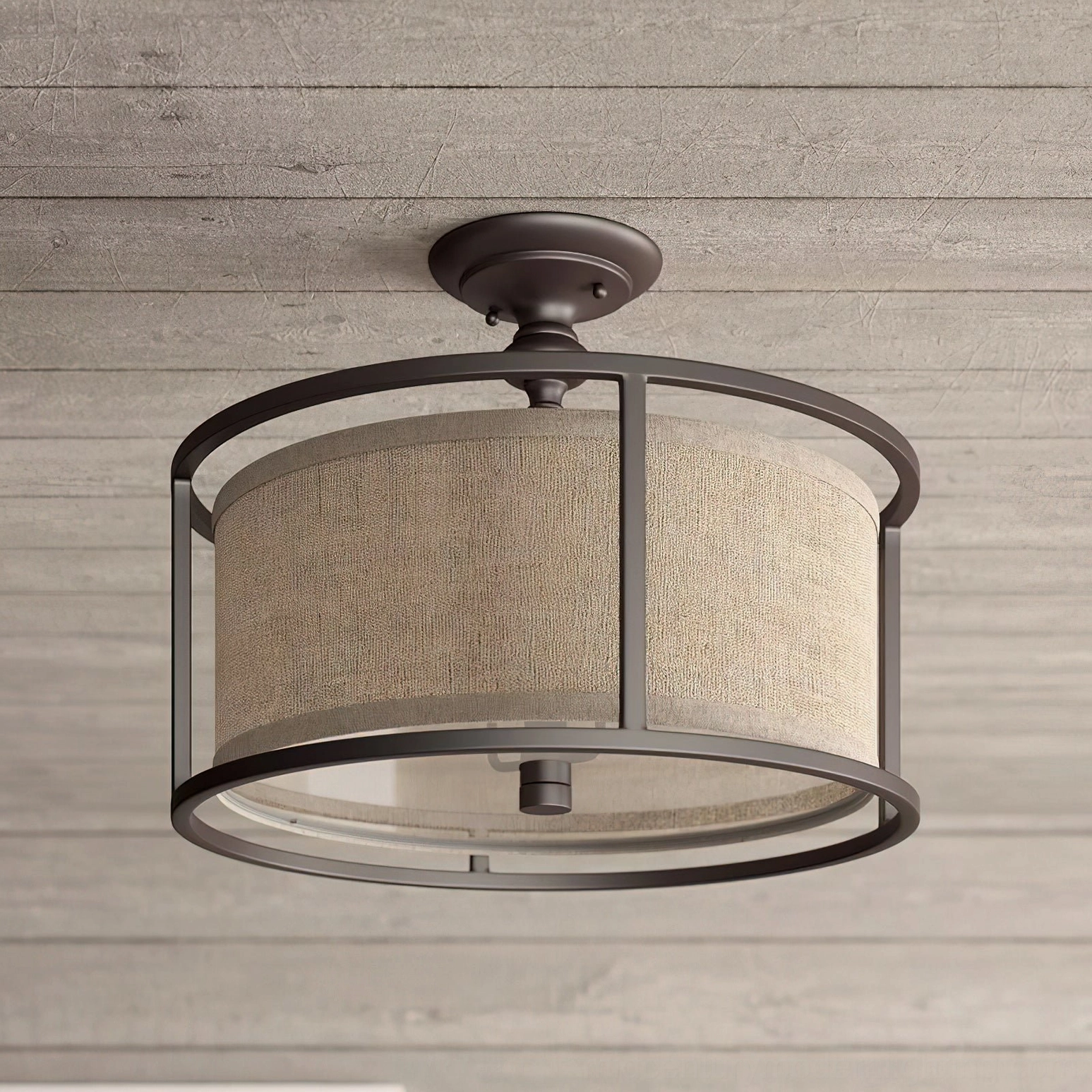 Addyson semi-flush ceiling lamp installed on rustic wood plank ceiling, low-angle view showcasing clear lower glass panel and warm diffused light in farmhouse style interior