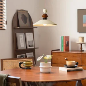 Mid-century Adelaide pendant light hanging over wooden round dining table in warm modern dining room