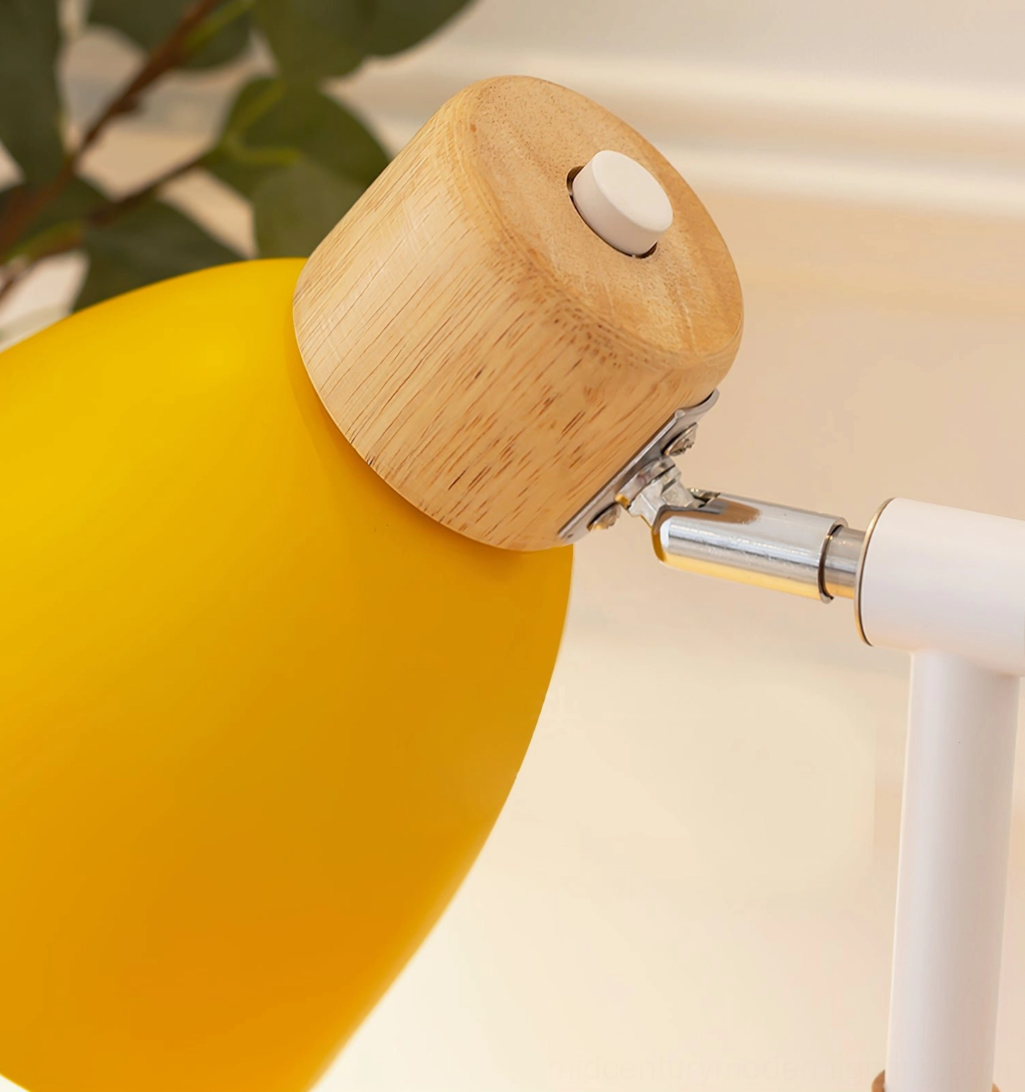 Close-up front view of white adjustment button and metal hinge structure on Scandinavian wood table lamp