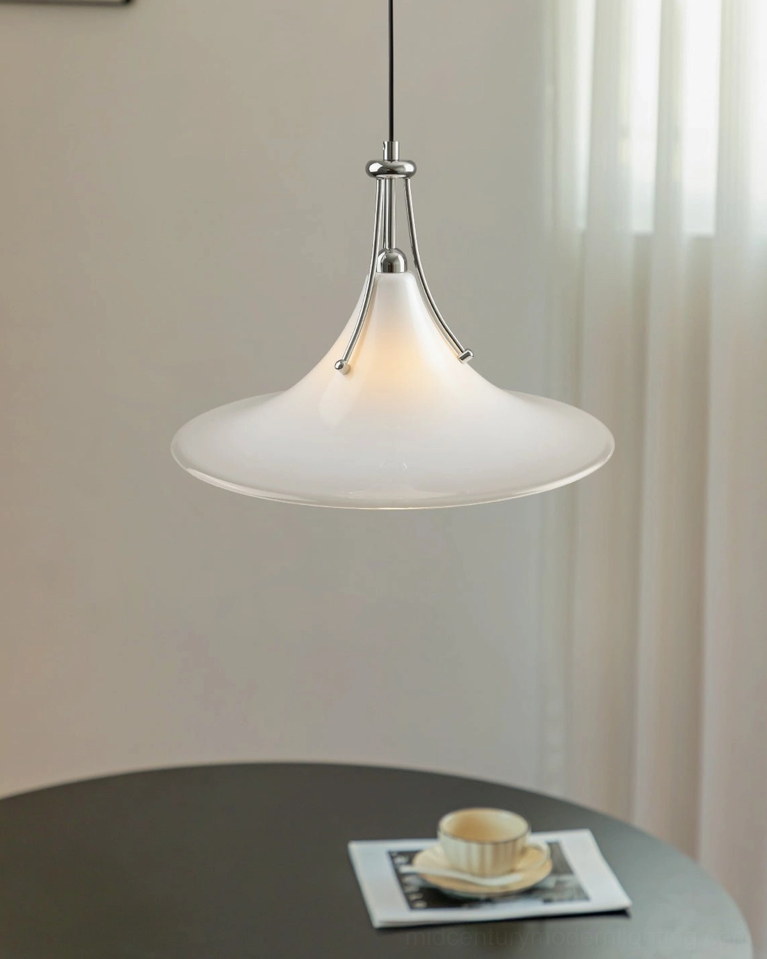 Adjustable swing arm pendant light with conical frosted glass shade positioned above compact dining table with dark round surface