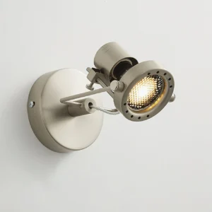 Close-up detail of adjustable wall spotlight showing warm illuminated LED bulb and metal support wire construction
