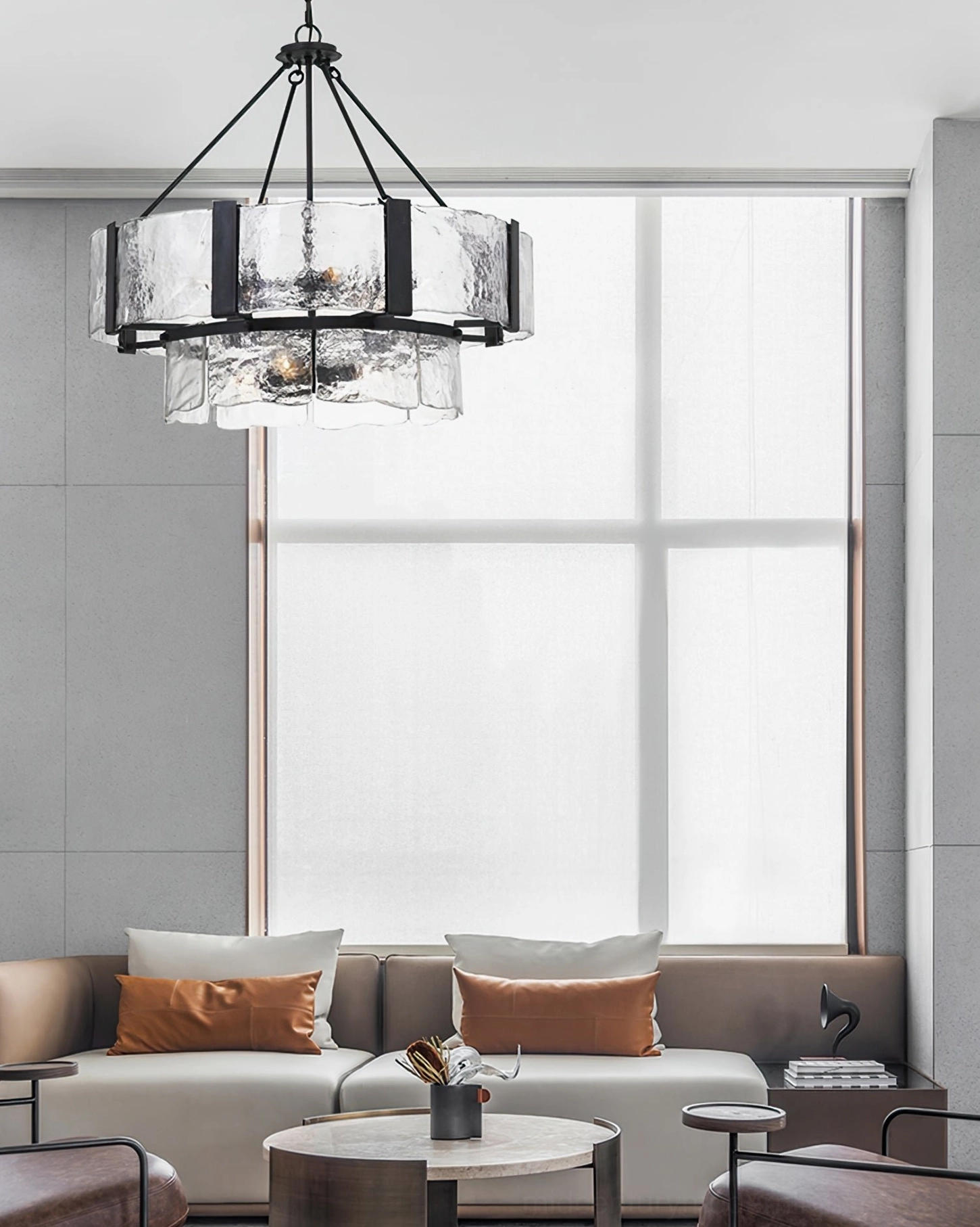 Double-layer glass chandelier in bright minimalist living space with large windows and grey interior design