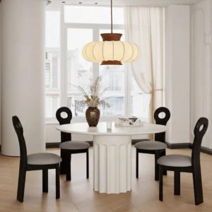 Aeron pendant light glowing above modern French dining room table with warm ambient lighting