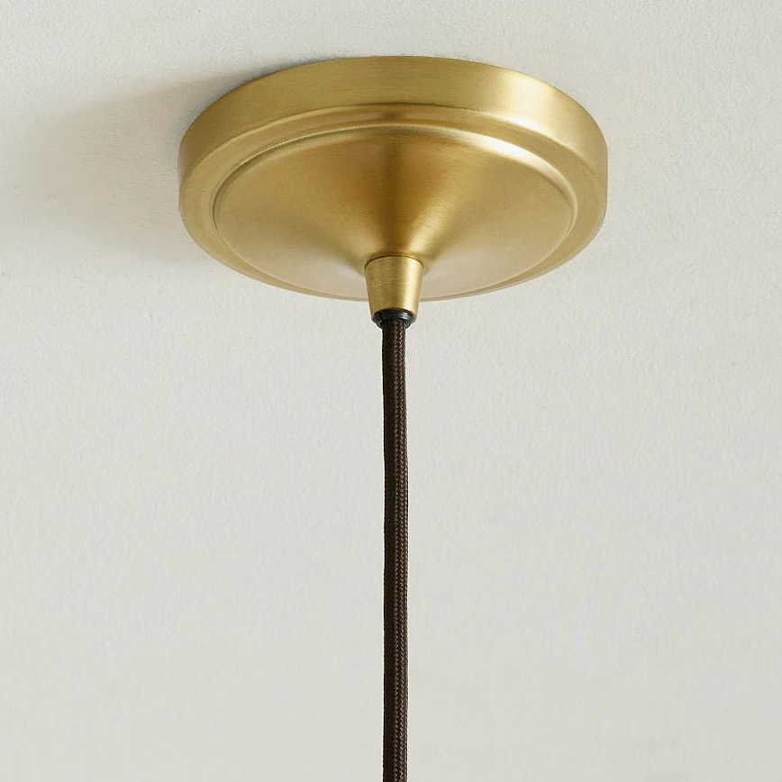 Agoura mid-century modern rattan pendant light with matte black fixture, studio presentation