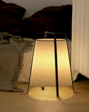 Akane table lamp placed on bedroom nightstand with warm ambient lighting, eye-level side view showing fabric shade glow