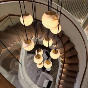 Overhead view of alabaster ball pendant chandelier installed in modern spiral staircase foyer