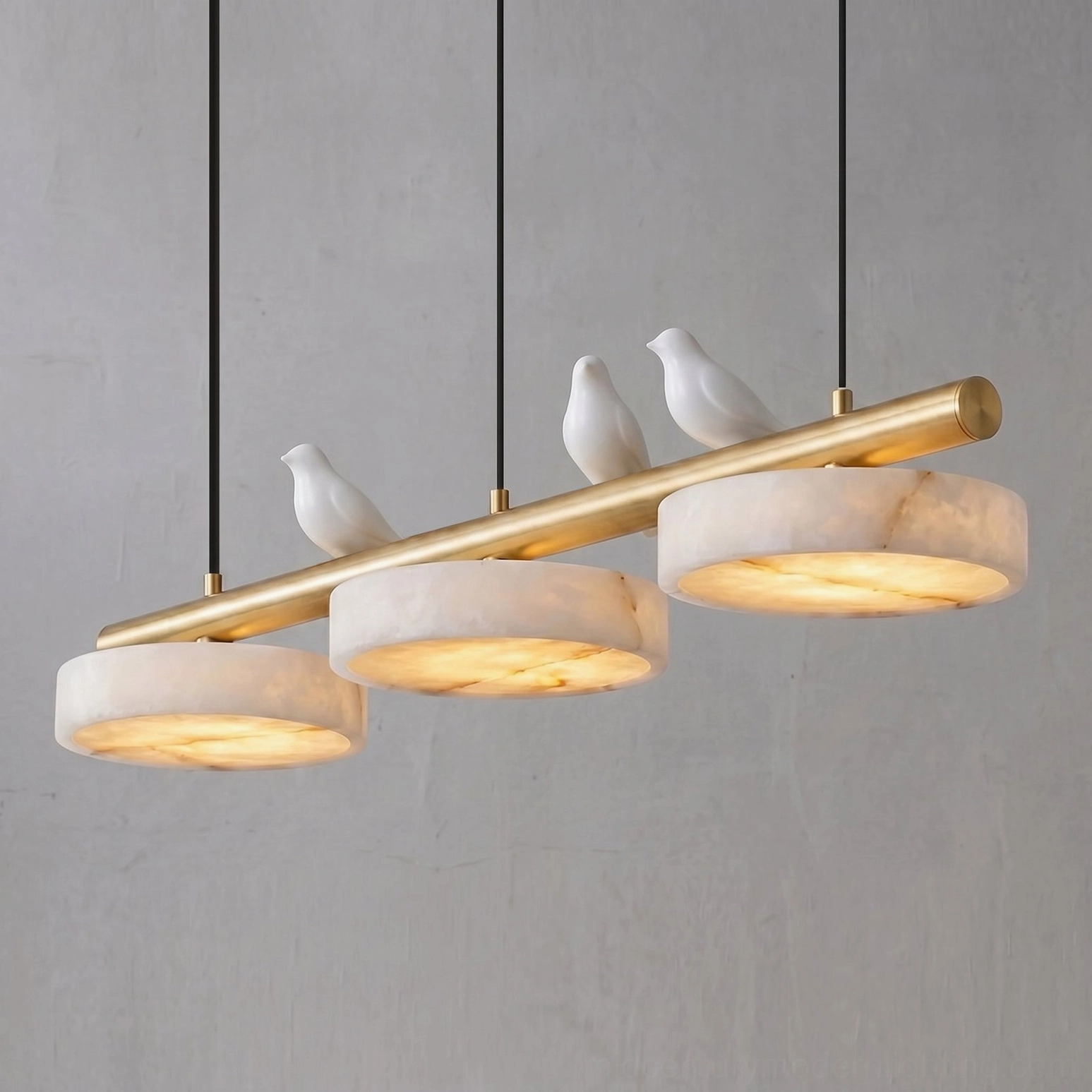 Close-up of warm glowing alabaster shades on brass linear chandelier with integrated LED