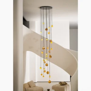Lit alabaster cluster chandelier installed above spiral staircase casting warm amber light in modern duplex