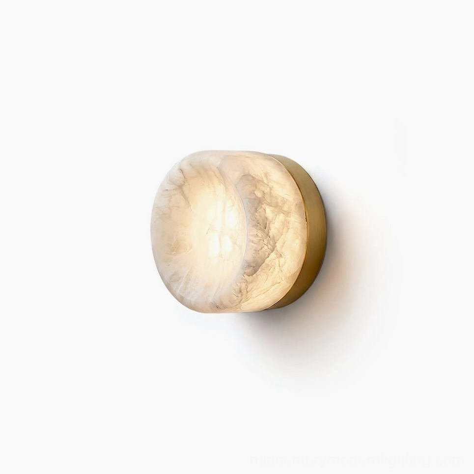 Concave disc alabaster wall sconce with brushed brass base on white background, flat frontal view showcasing stone translucency