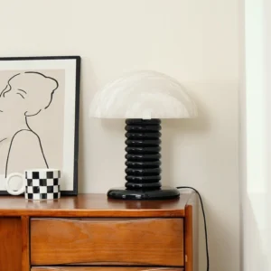 Minimalist table lamp on wooden bedside table with home décor accents and checkered mug