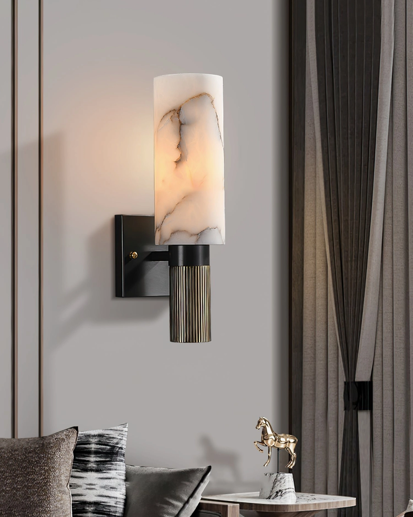 Single alabaster marble wall sconce in contemporary hallway with tabletop decor, stacked books, and ambient lighting