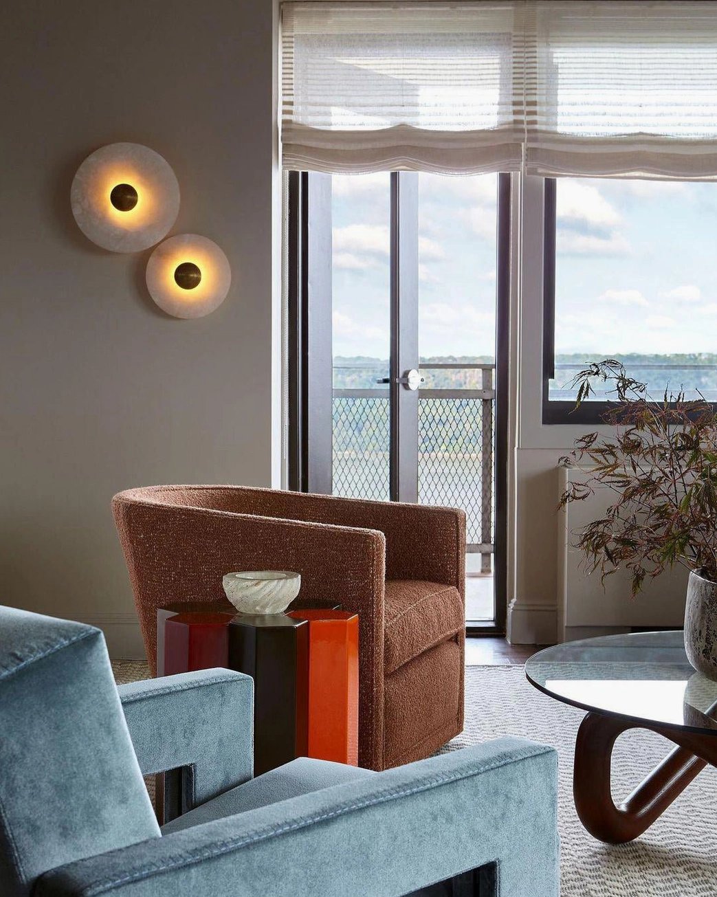 Mid-century modern interior with alabaster wall light, brass accents, vintage-inspired design pairing