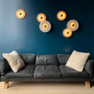 Modern living room with multiple warm-glowing alabaster wall lights, leather sofa with fur accents, deep blue accent wall