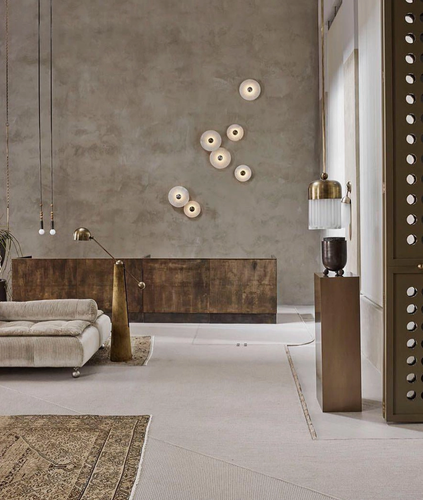 Modern rustic living room with scattered alabaster wall lights, concrete accent wall, warm wood furniture