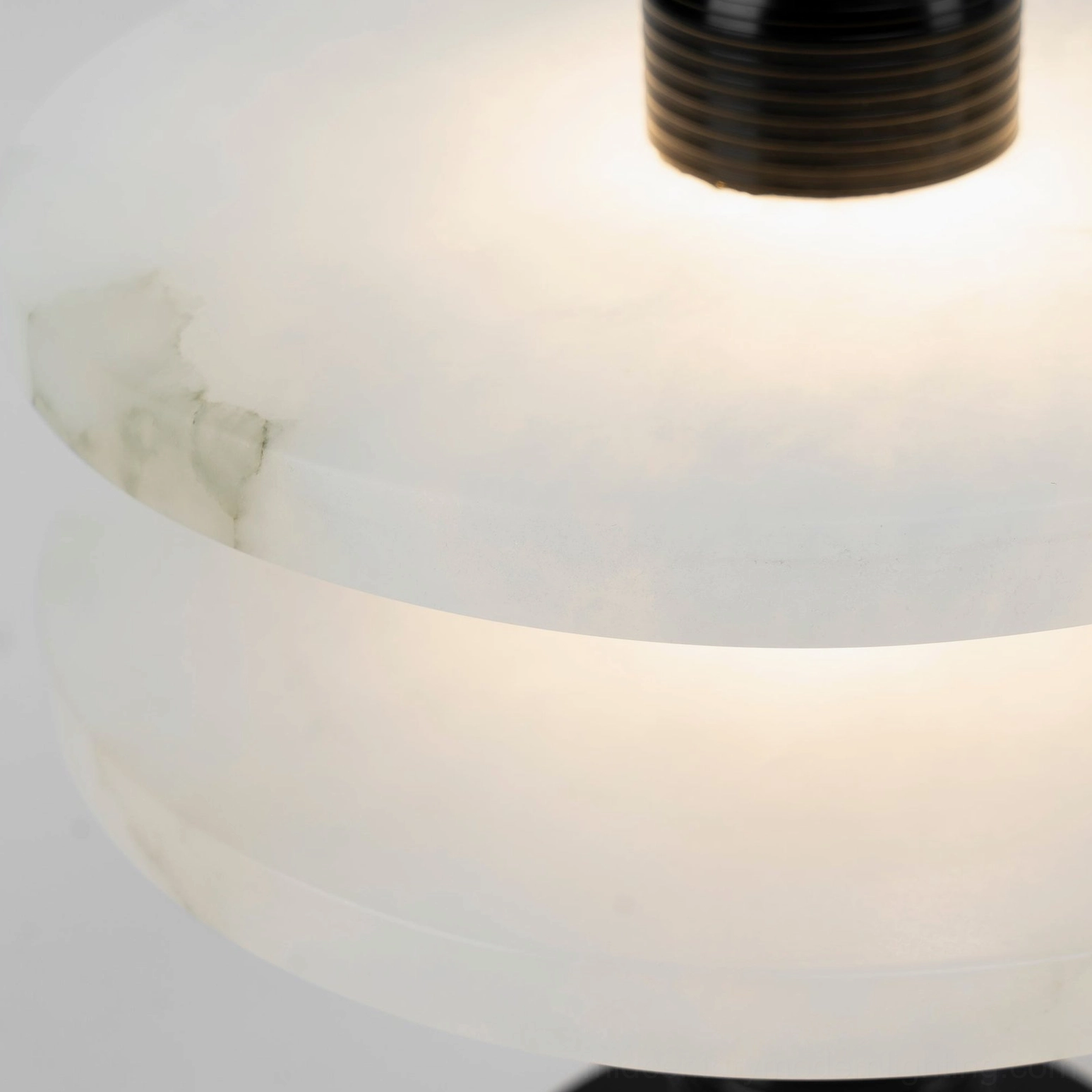 Illuminated Alabaster Planes Table Lamp detail showing warm LED glow through translucent alabaster and ribbed metal top