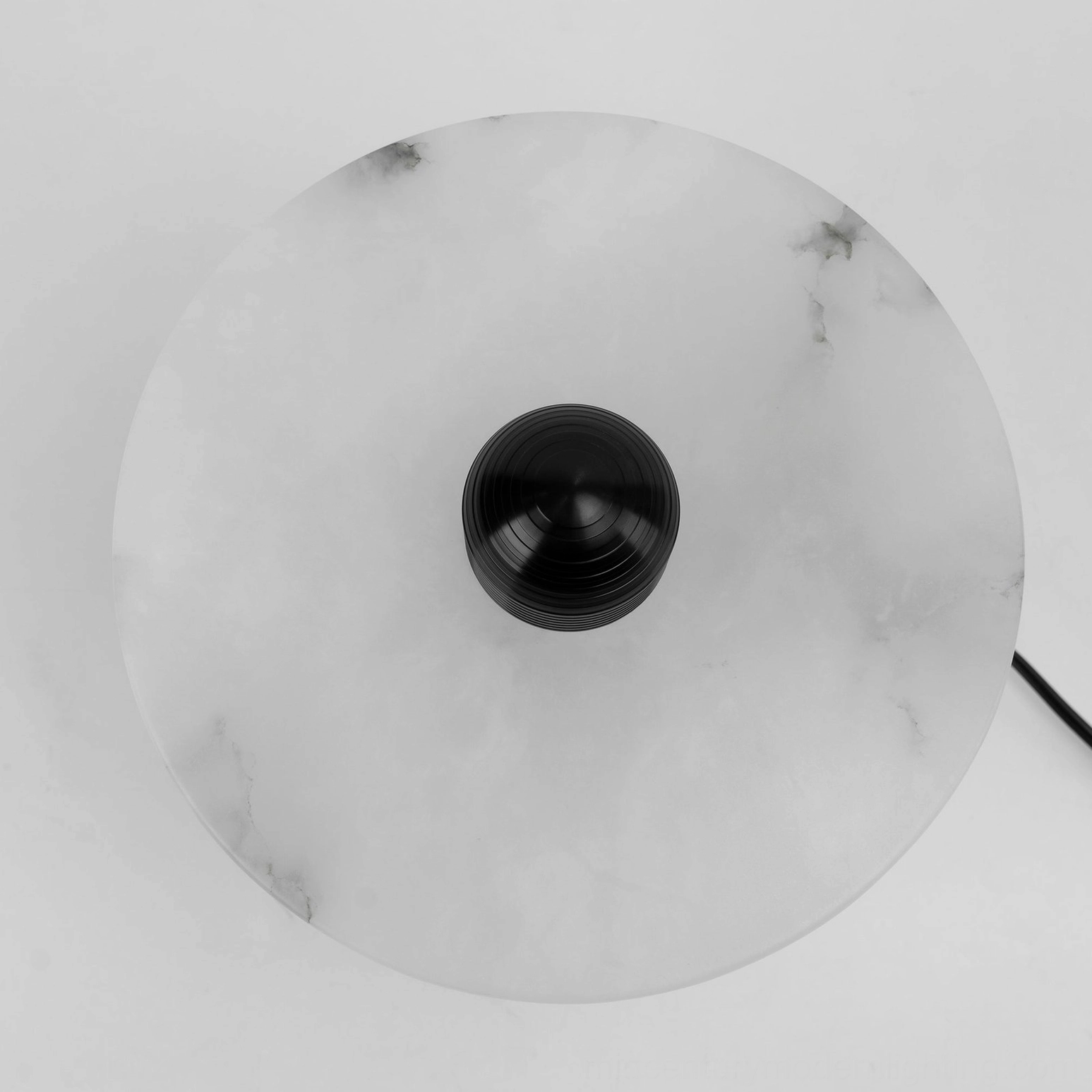 Close-up top view of Alabaster Planes Table Lamp white alabaster shade with natural veining and black metal fitting