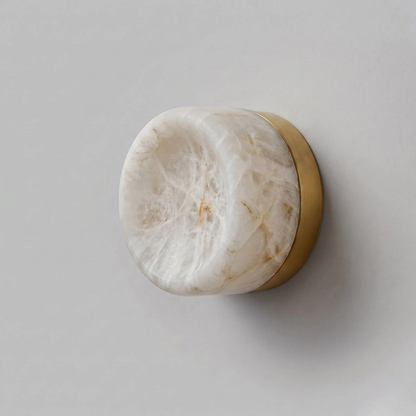 Concave alabaster disc wall sconce architectural detail showing carved stone profile and metal bracket assembly