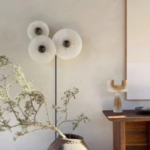 Multi-lamp alabaster wall sconce in minimalist boho living room with dried plant styling and warm neutral decor