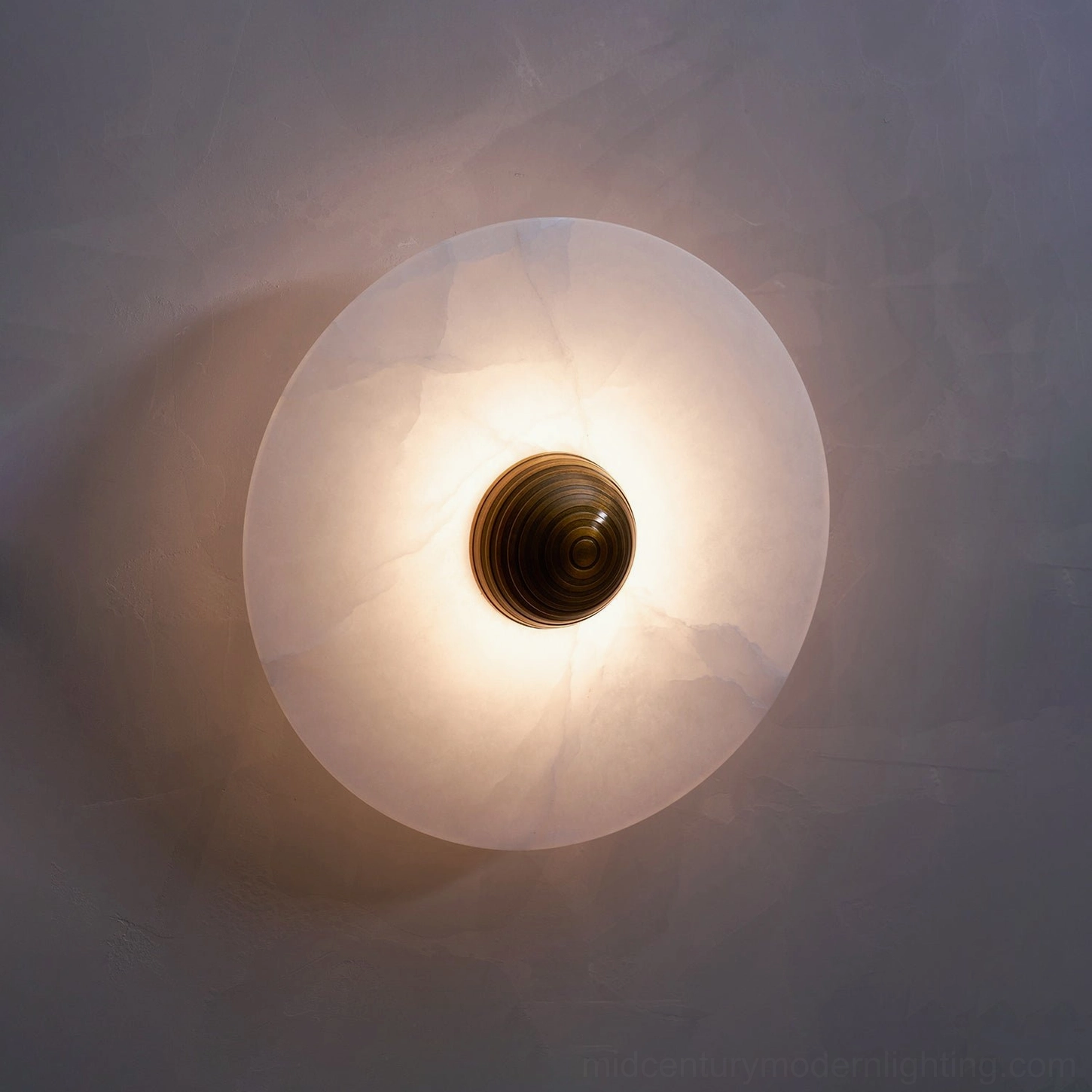 Round alabaster lights in coordinated pairs, matching bronze finishes, symmetrical room design