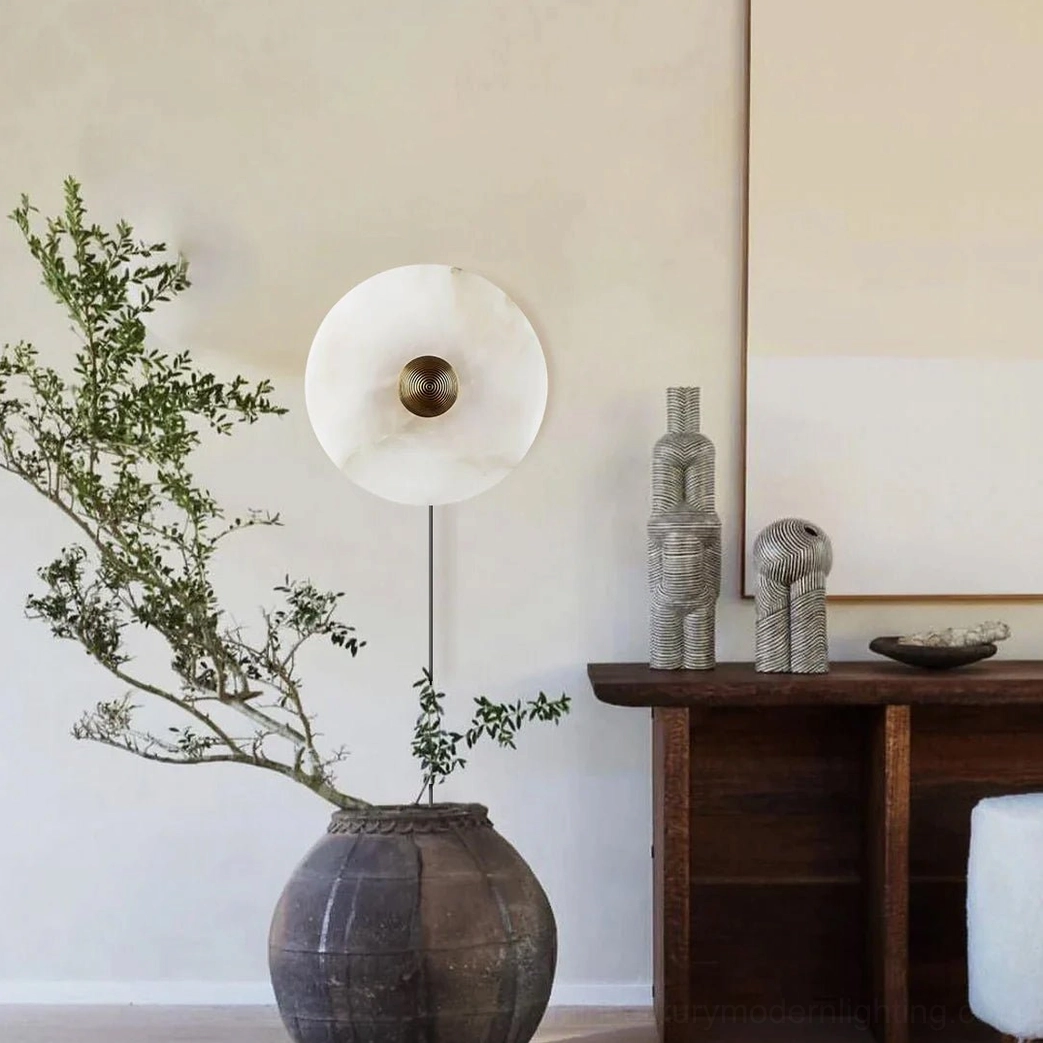 Modern alabaster wall sconce mounted in minimalist interior with potted plant, indoor ambient lighting