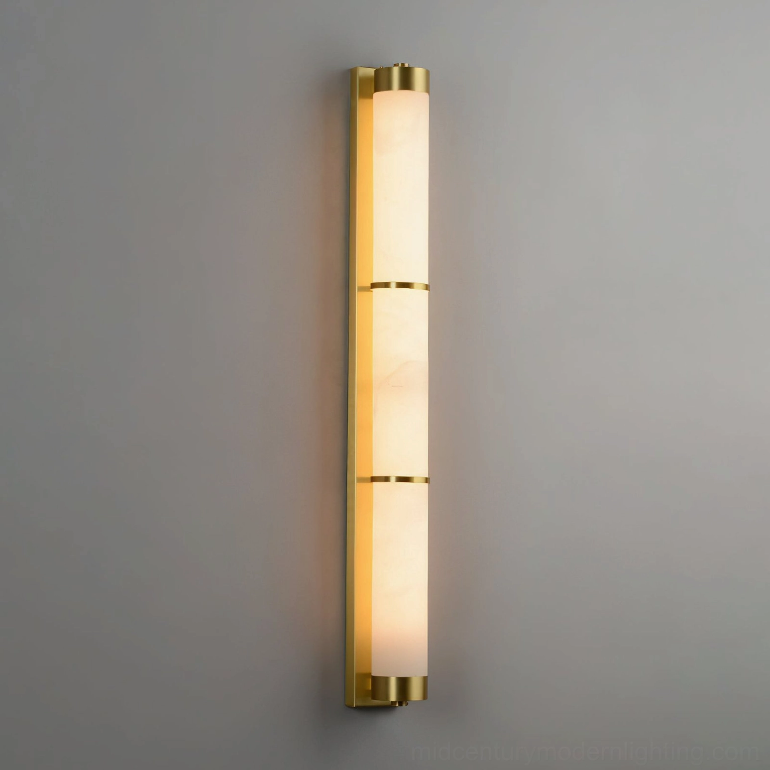 Tall tubular alabaster wall light fixture with brass gold hardware accents and three-section marble shade design