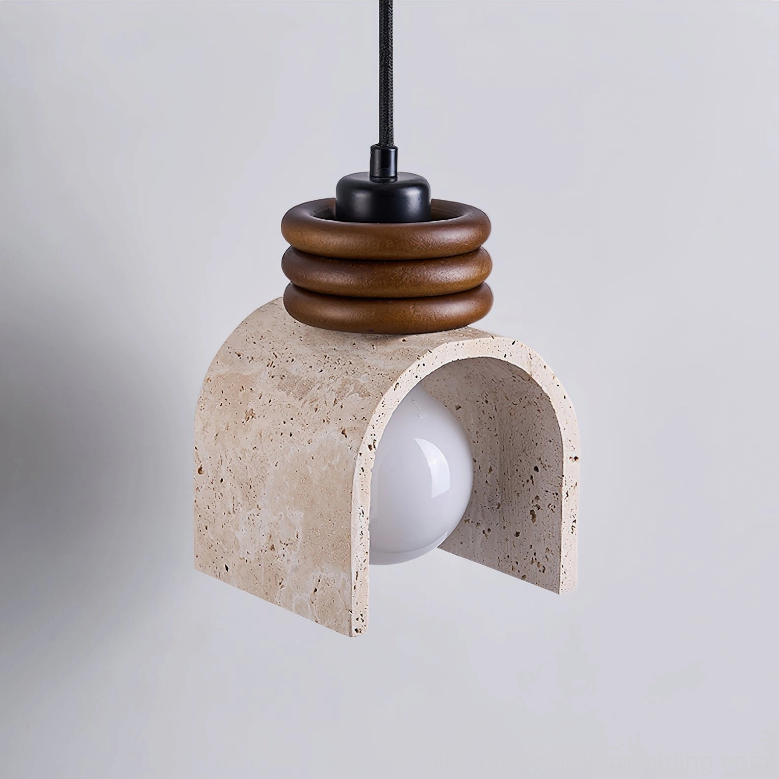 Alagusmo travertine pendant lamp three-quarter view against soft gray backdrop with stacked wooden rings