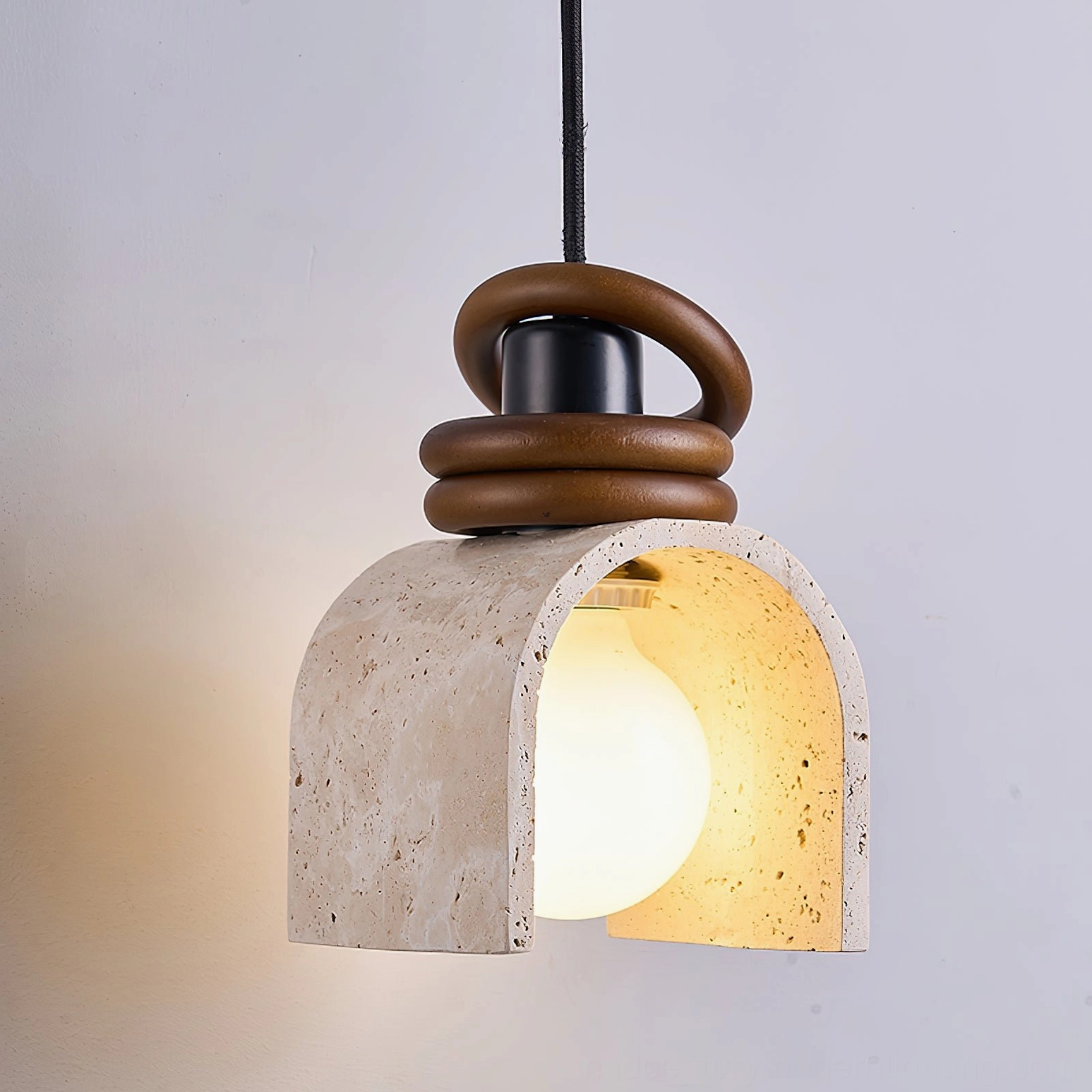 Alagusmo pendant light side angle showing twisted walnut wood ring accent and natural stone travertine arch