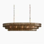 Albano tiered glass chandelier in smoky amber finish, overhead frontal studio view showcasing hand-assembled art glass louvers and brutalist mid-century modern design