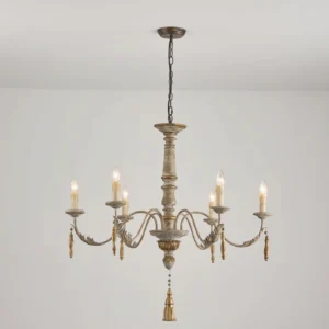 Alda chandelier illuminated in minimalist interior, low-angle view showing warm candlelight and tassel drop details