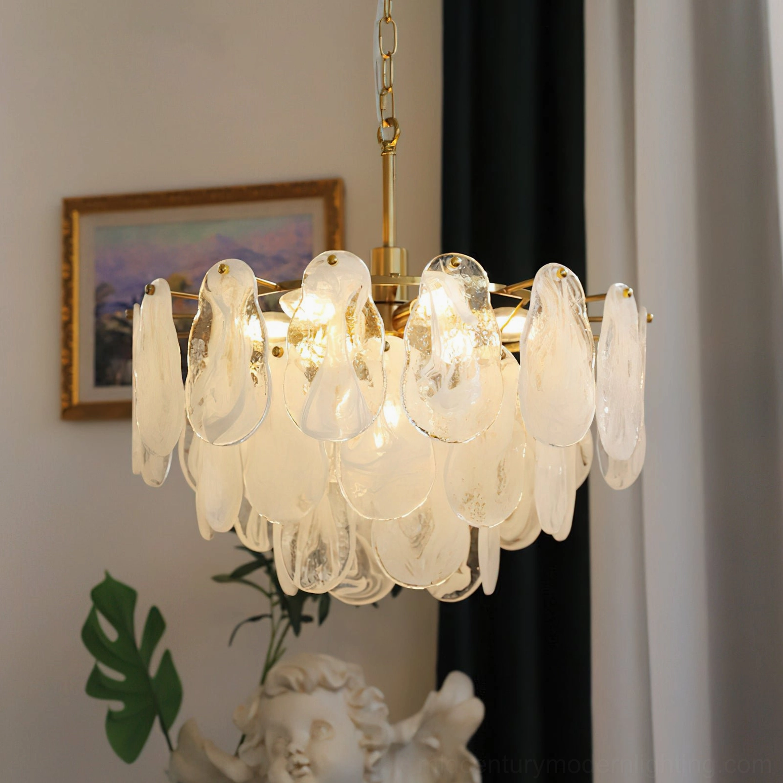 Alessia Glass Chandelier lit in luxury home interior, warm glow from brass frame and marbled glass shades