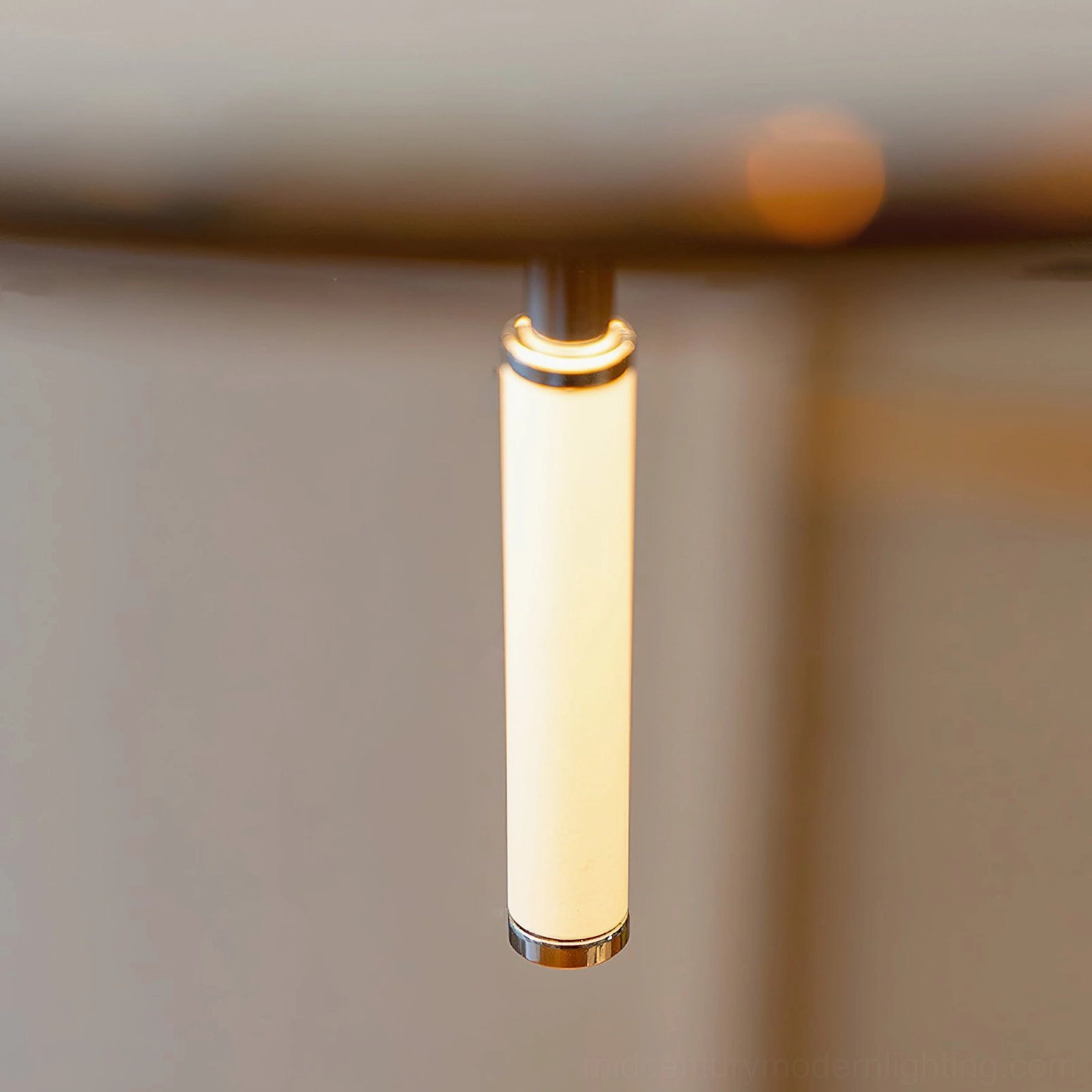 Close-up detail of frosted acrylic cylinder and chrome metal trim on alien pendant light