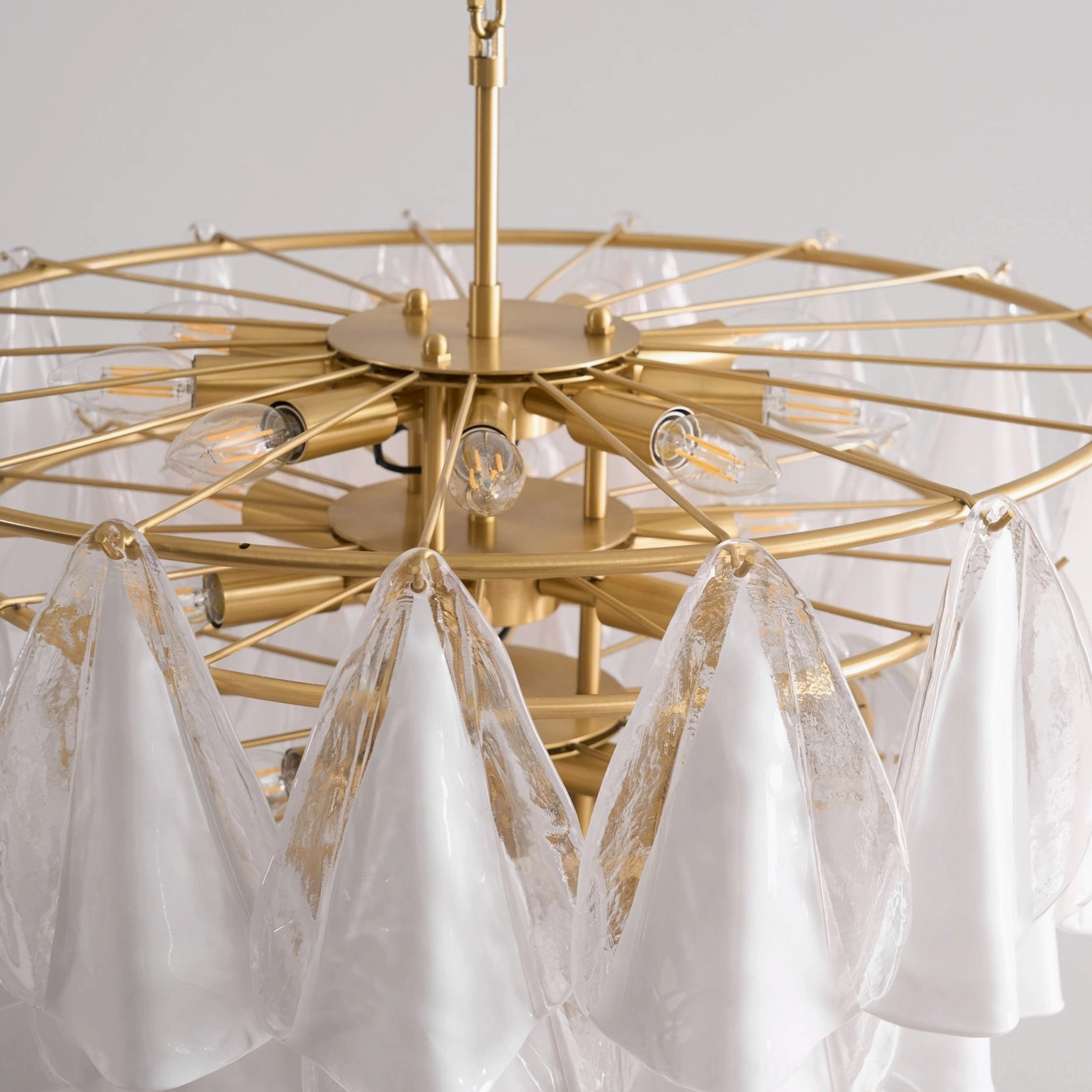Alira tiered glass chandelier top-down close-up showing exposed brass fixture and bulb sockets
