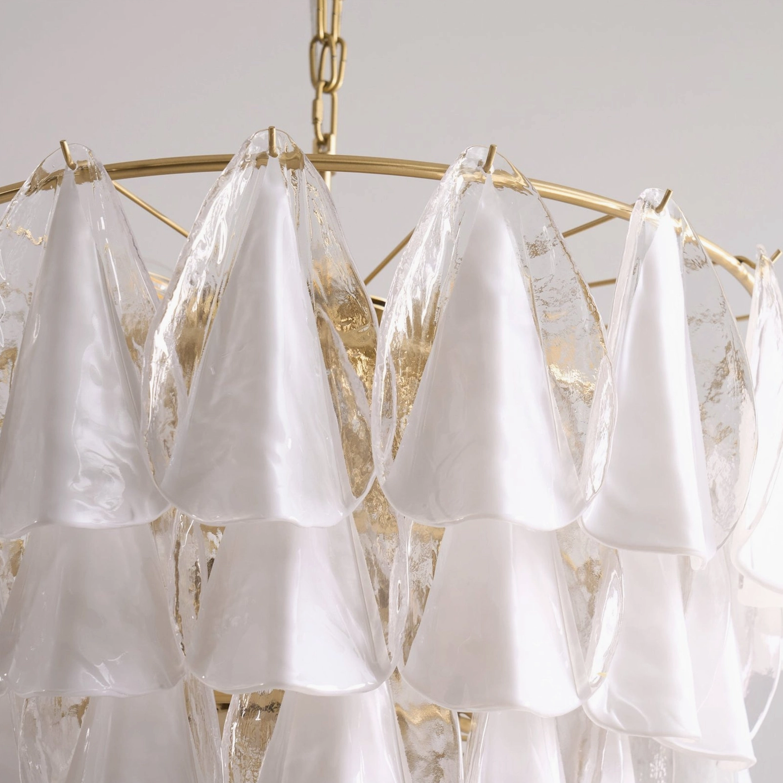 Alira glass chandelier bottom view showing conical frosted glass shades and brass metal framework structure