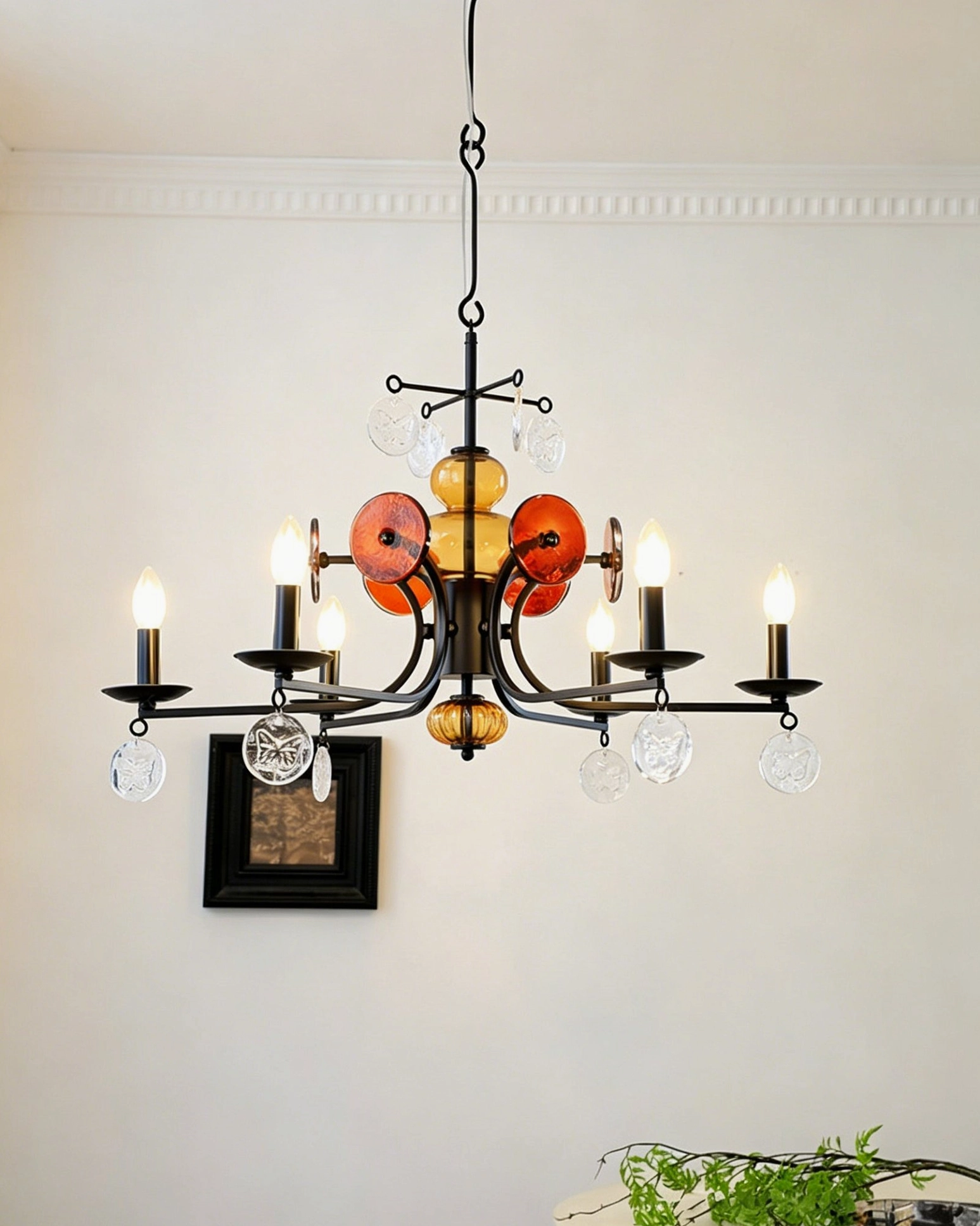 Side view of Alistair six-light glass chandelier with minimalist wall frame in neutral room