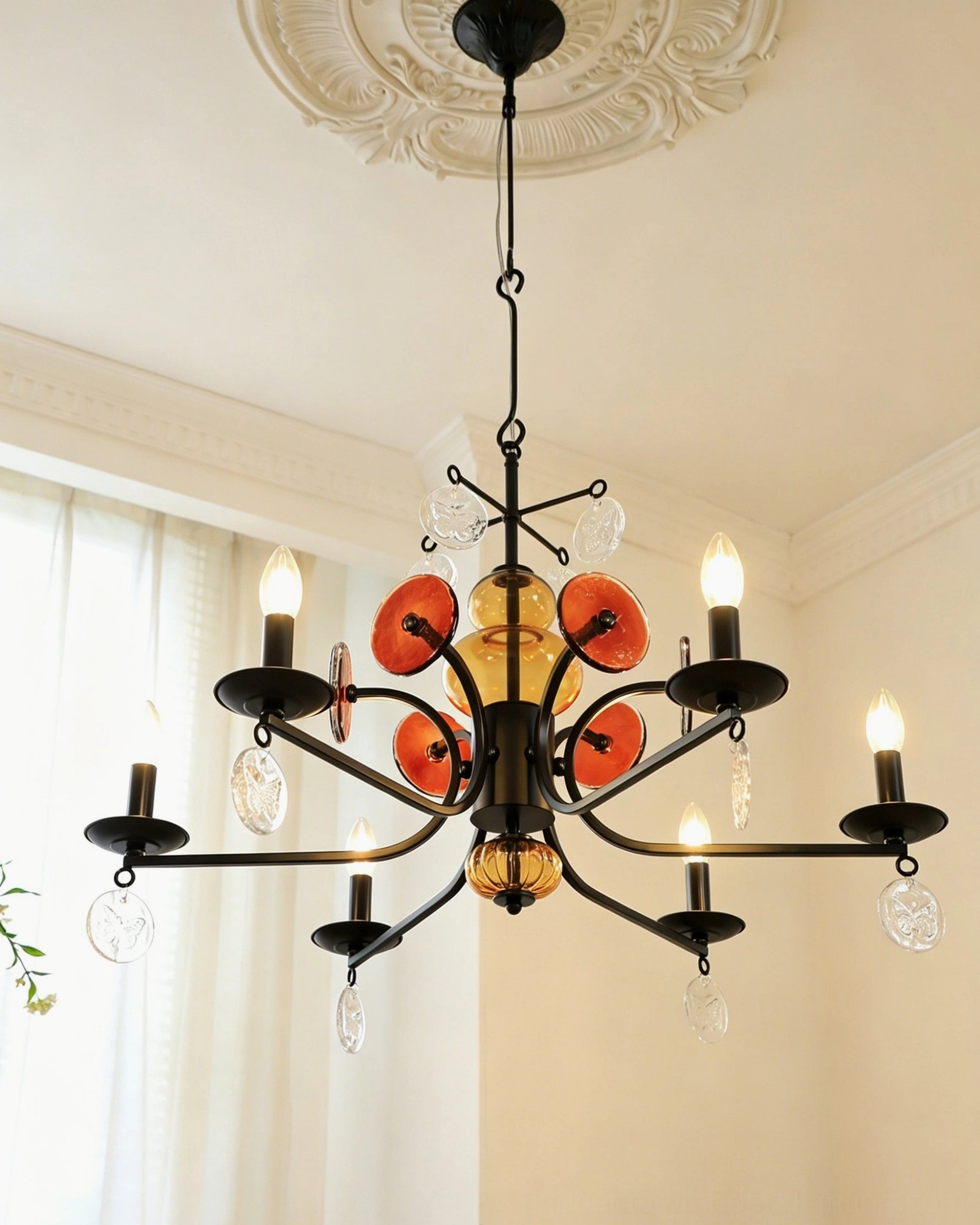 Alistair chandelier with ornate ceiling medallion showing black metal framework and warm amber glass accents