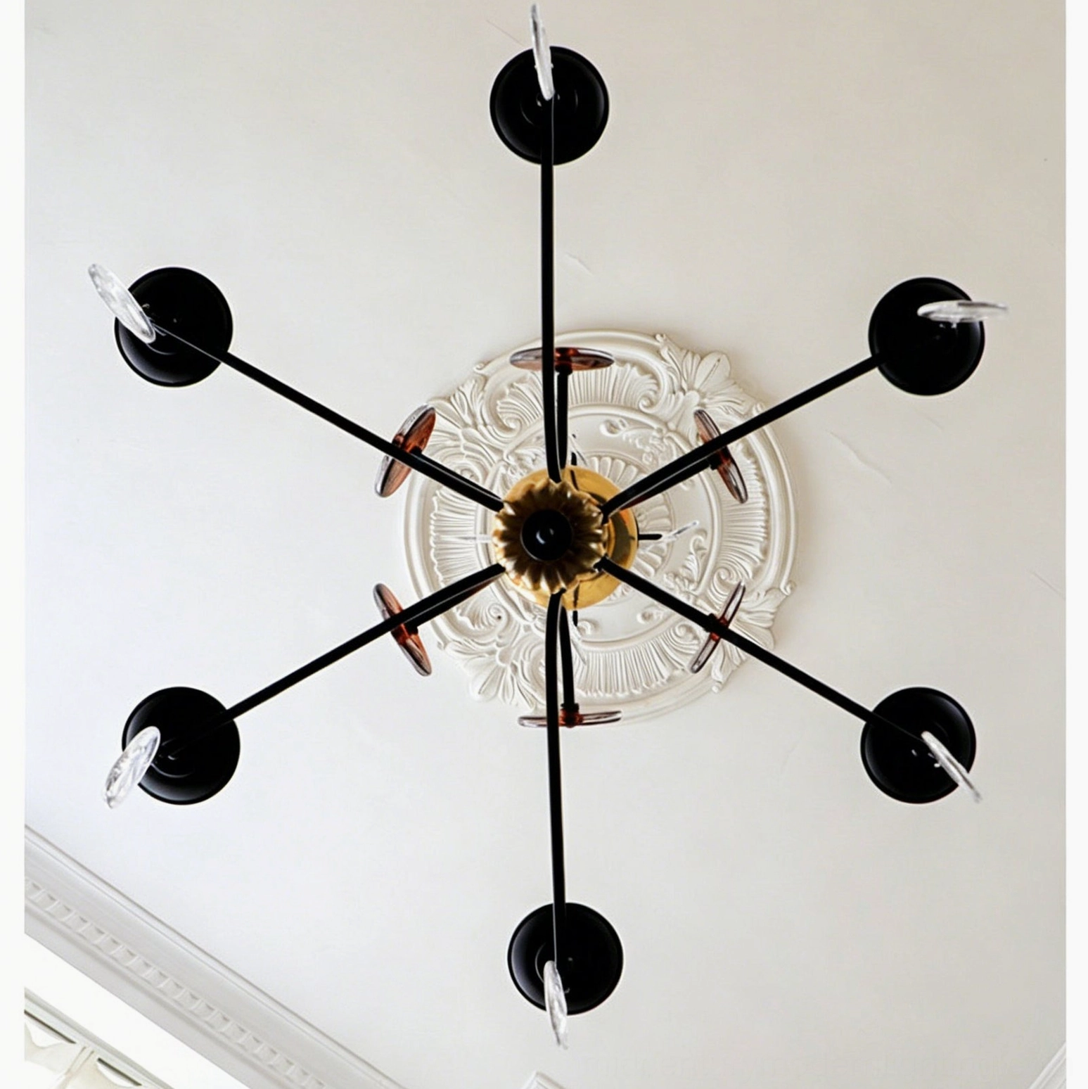 Alistair mid-century modern candle chandelier detail showing hand-blown amber glass and iron scroll construction