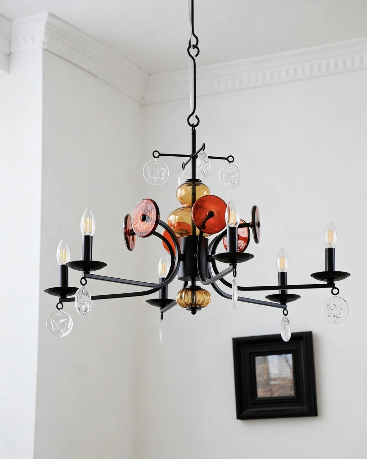 Side angled view of Alistair mid-century modern chandelier with terracotta glass ornaments and black metal scrolls