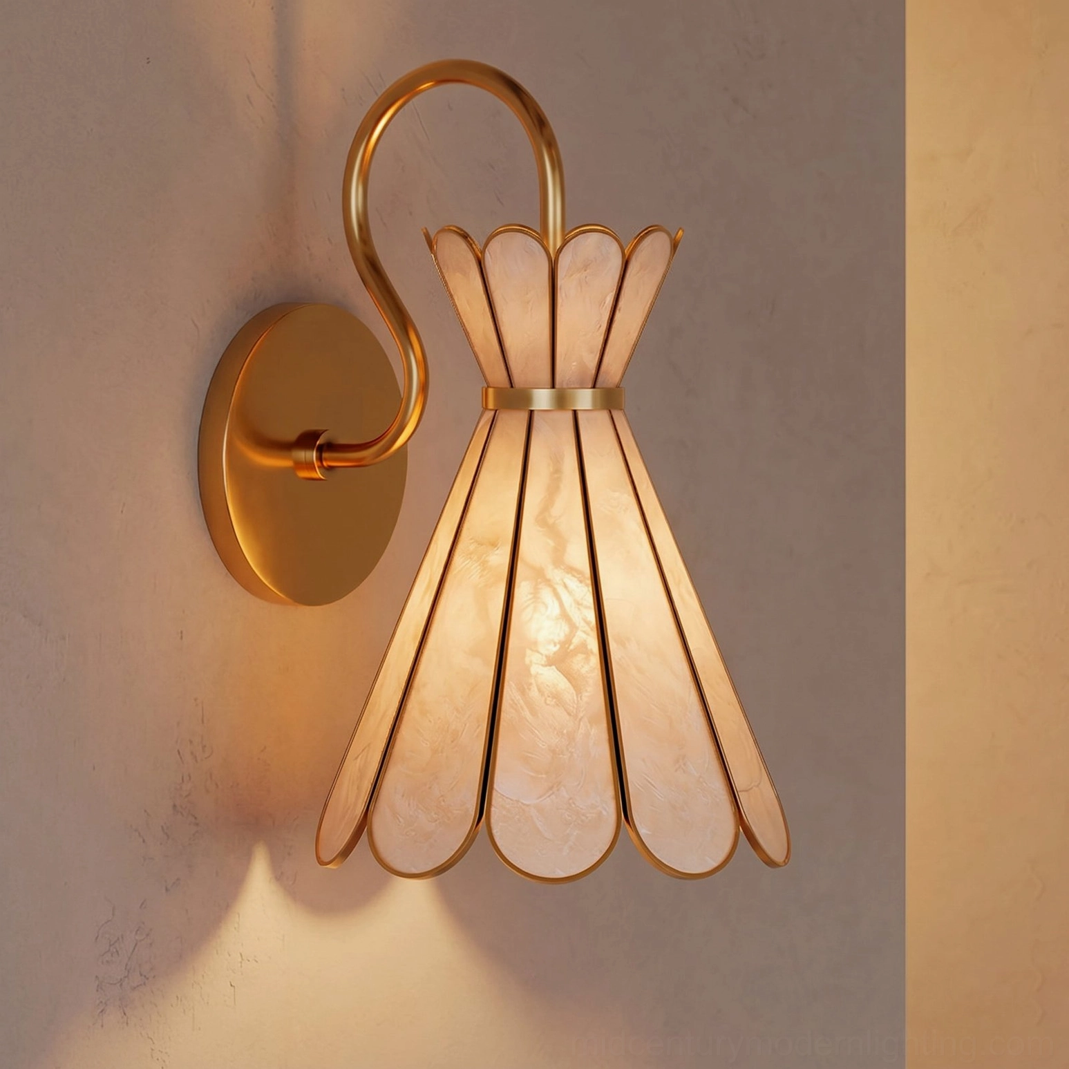 Alito brass wall light illuminated with warm ambient glow, close-up front perspective on textured indoor wall